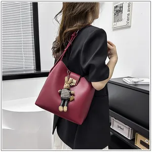 Détail du sac seau bordeaux avec fermoir en métal et charmant porte-clés lapin en peluche