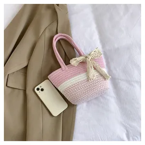 Detail of pink and white striped woven bag with cream lace bow and cotton handles