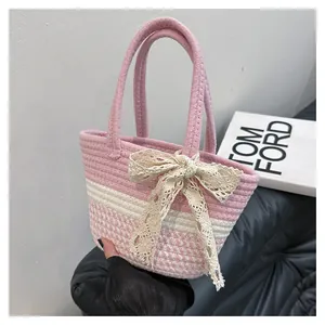 Close-up of pink and white hand-woven tote bag with elegant lace bow detail