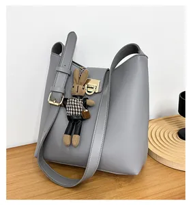 Détail du sac seau en cuir gris avec boucle dorée et breloque lapin mignonne