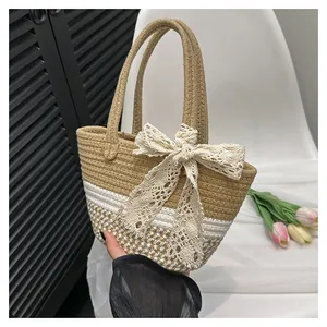 Close-up of handwoven straw tote with large lace bow and circular handles
