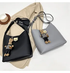 Détail de sacs hobo chics avec finitions dorées et pendentif lapin en peluche mignon