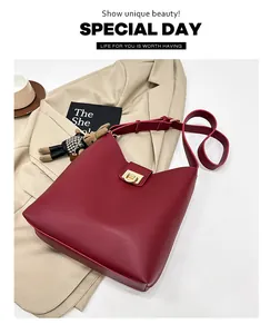 Détail du sac seau en cuir mat rouge avec boucles dorées et breloque lapin en peluche