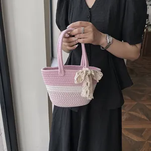 Pink and beige woven tote bag with delicate lace bow decoration for casual beach vacations