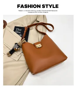 Détail du sac seau en cuir marron avec fermoir doré et charmant pendentif lapin en peluche
