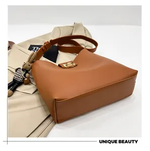 Détail du sac seau en cuir caramel avec fermoir tournant doré et breloque lapin mignonne