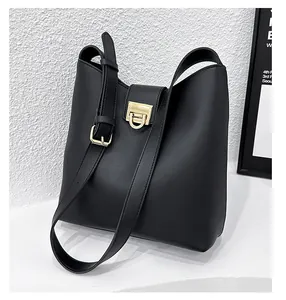 Détail du sac seau noir texturé avec un fermoir rotatif en métal doré poli brillant
