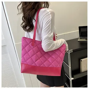 Quilted tote bag in bright pink with diamond stitching and leather strap shown on model