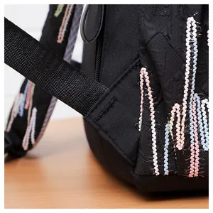 Detailaufnahme des schwarzen Rucksacks mit verstärkten Nähten und bunter Wellenstickerei