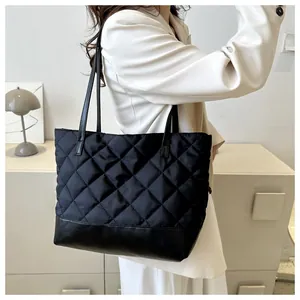 Quilted black tote bag showing spacious design and durable nylon material on model