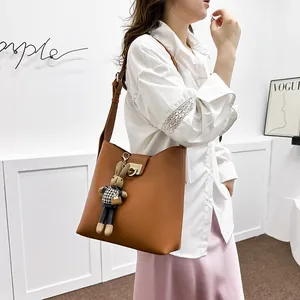 Sac seau chic en cuir marron avec fermoir anneau doré et breloque lapin sur tenue en dentelle