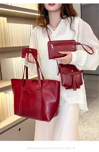 Detailed view of 4-piece dark red leather bag set with tote, crossbody and tassel charm