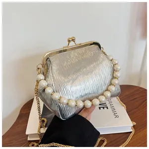 Silver pleated evening clutch bag with pearl handle and golden chain detail closeup