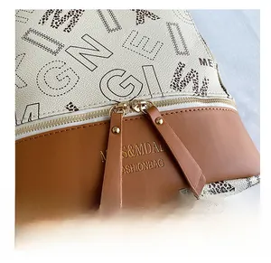 Detail of smooth golden metal zippers and premium lychee pattern leather on fashion backpack