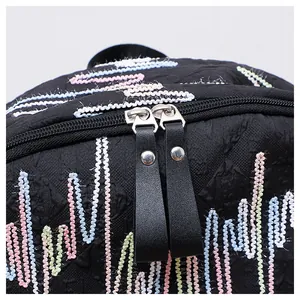 Detailansicht der schwarzen Rucksacktextur mit bunten Wellenstickereien und Doppelreißverschluss