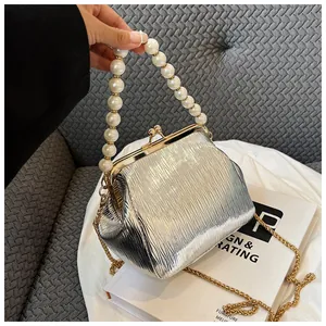 Detail of silver pleated shell bag with pearl handle and metallic frame closure
