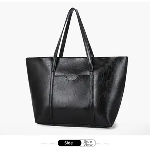 Side view of black faux leather tote bag showing U-shaped stitching and glossy texture