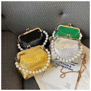 Detail of pleated shell bags with pearl handles and metal clasps in various metallic colors
