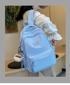 Close-up of light blue nylon school backpack with multiple compartments and cute charm