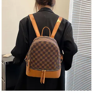 Detail of a brown checkered PU leather backpack with tassel zippers on a black blazer
