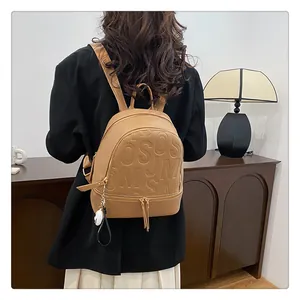 Detail of khaki pebbled leather backpack with embossed letters and tassel zipper pull