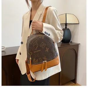 Close-up of brown and yellow PU leather backpack with letter prints and metal zippers