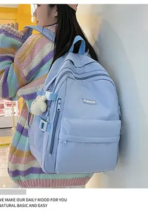 Light blue school backpack with cute bear pendant and side buckle detail in close-up shot