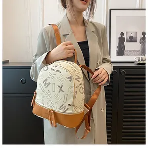Close-up of white and brown patterned leather backpack worn with a grey blazer