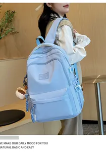 Close-up of light blue nylon backpack featuring a cute bear keychain and haqhiyq logo