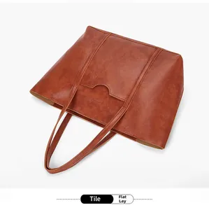 Flat lay of vintage brown PU leather tote bag with front pocket and dual handles