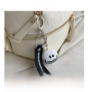 Close-up of golden zipper and smiley face charm on white lychee leather backpack
