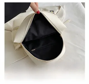 Internal capacity of the beige backpack featuring a black fabric lining and a zipper pocket