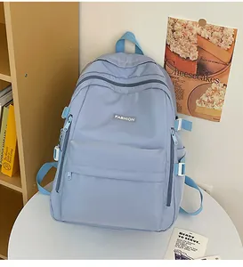 Close-up of a light blue nylon school backpack with adjustable side straps and fashion label