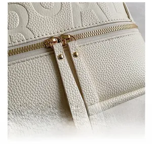 Detail of white lychee leather backpack with golden double zipper and embossed letters
