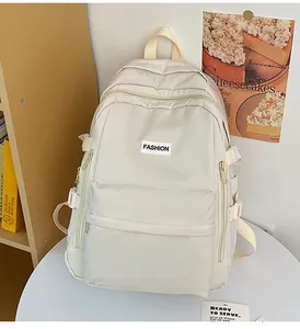 Detail view of large capacity beige nylon school backpack with multi-pocket design