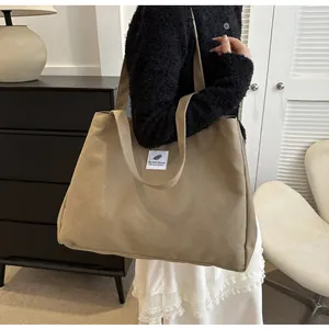 Détail d'un grand sac cabas en toile kaki avec logo feuille et doubles bretelles minimalistes