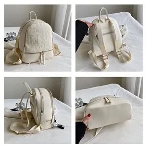 Four-angle view of off-white lychee grain leather backpack with gold zippers and metal charms