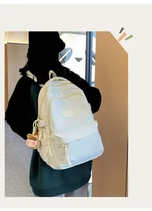 Detail of white nylon backpack with HAOHIYO logo and cute cartoon charm on side