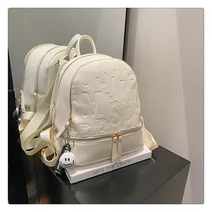 Detail of cream waterproof backpack with embossed letters and textured leather finish