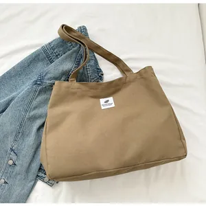 Détail du grand sac cabas en toile kaki avec étiquette en tissu et intérieur spacieux