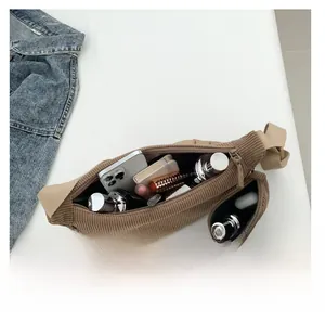 Brown corduroy waist bag showing internal capacity for phone, cosmetics and notepad