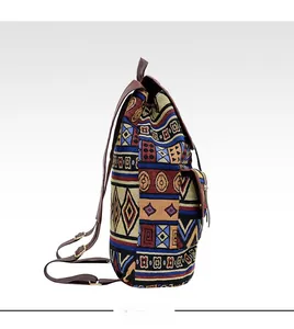 Side view of ethnic woven backpack showing canvas texture and brown leather side pocket