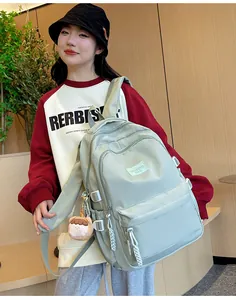 Side view of mint green nylon backpack with adjustable straps and cute girl pendant