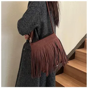 Vue détaillée d'un sac seau à franges en daim marron foncé porté par un mannequin