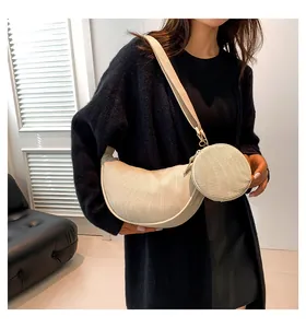 Detail of off-white corduroy dumpling bag texture with matching round coin pouch and strap