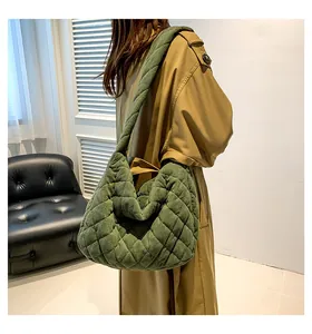 Detail of green quilted corduroy hobo bag showing soft diamond texture and wide strap