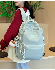 Detail of mint green waterproof nylon backpack with side buckle and cute plush pendant