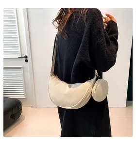 Detail of off-white corduroy crescent bag with small round coin purse attachment