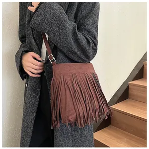 Détail du sac seau à franges marron foncé avec texture daim mate et sangle réglable