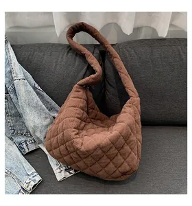 Detail of quilted corduroy texture and diamond stitching on brown tote bag